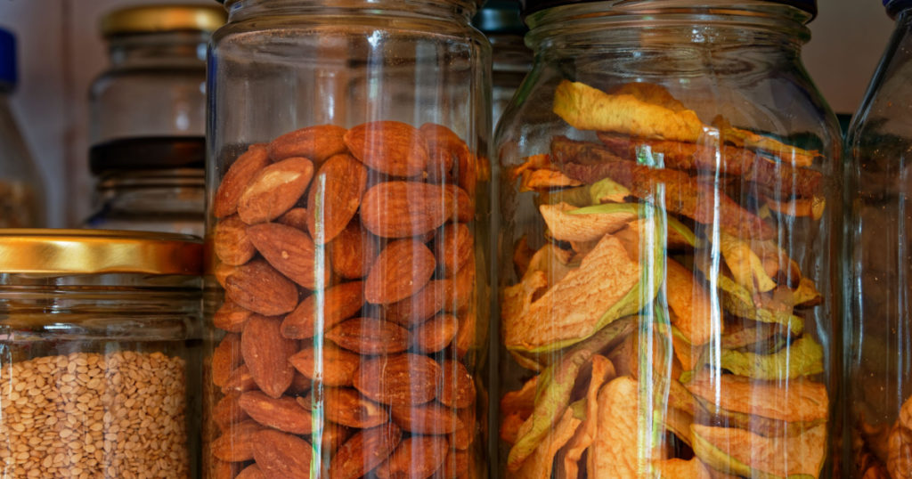 Almonds and dried apple slices stored in glass jars, reducing the use of plastic 