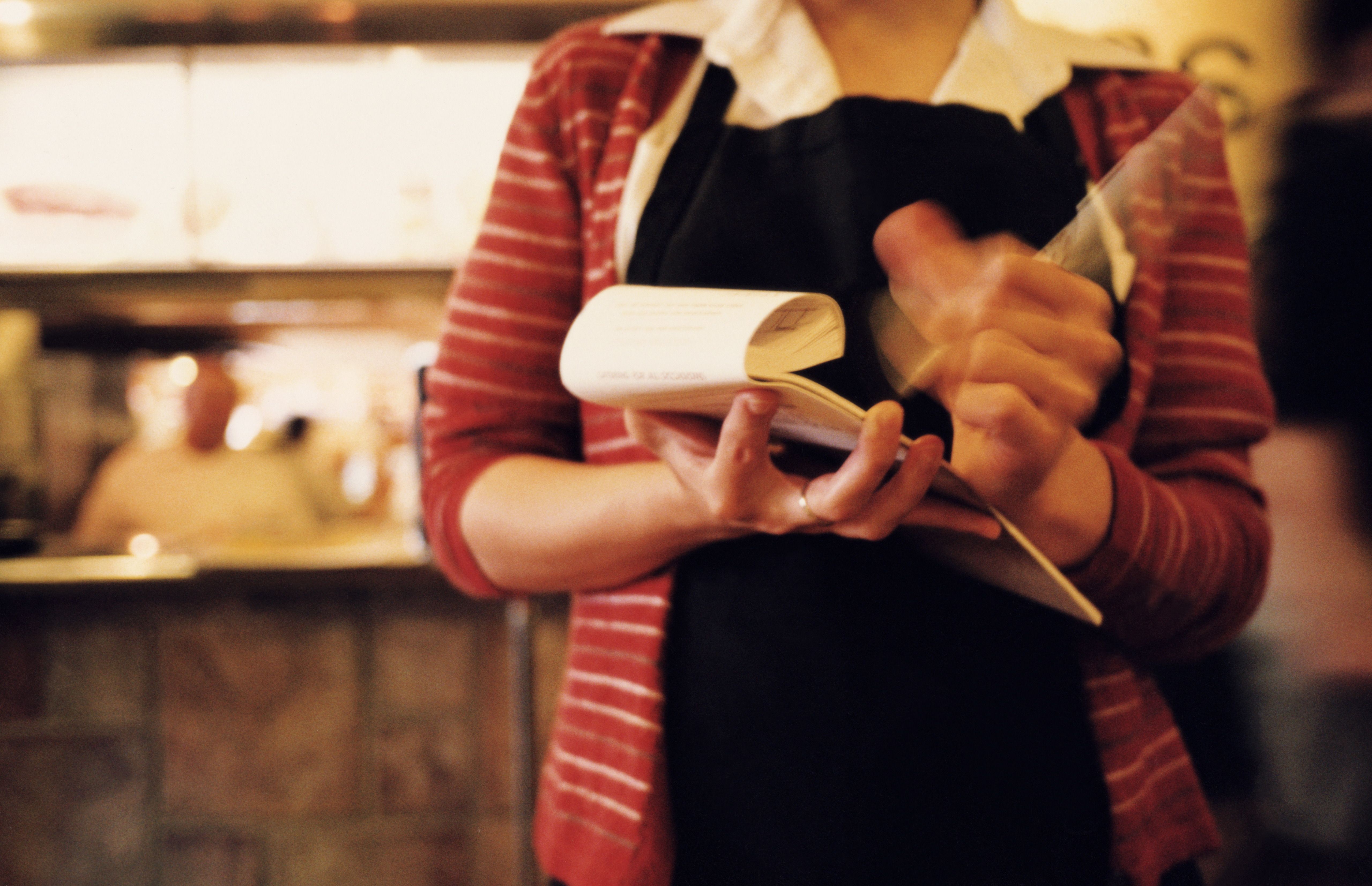 A waitress holding a receipt | Source: Getty Images