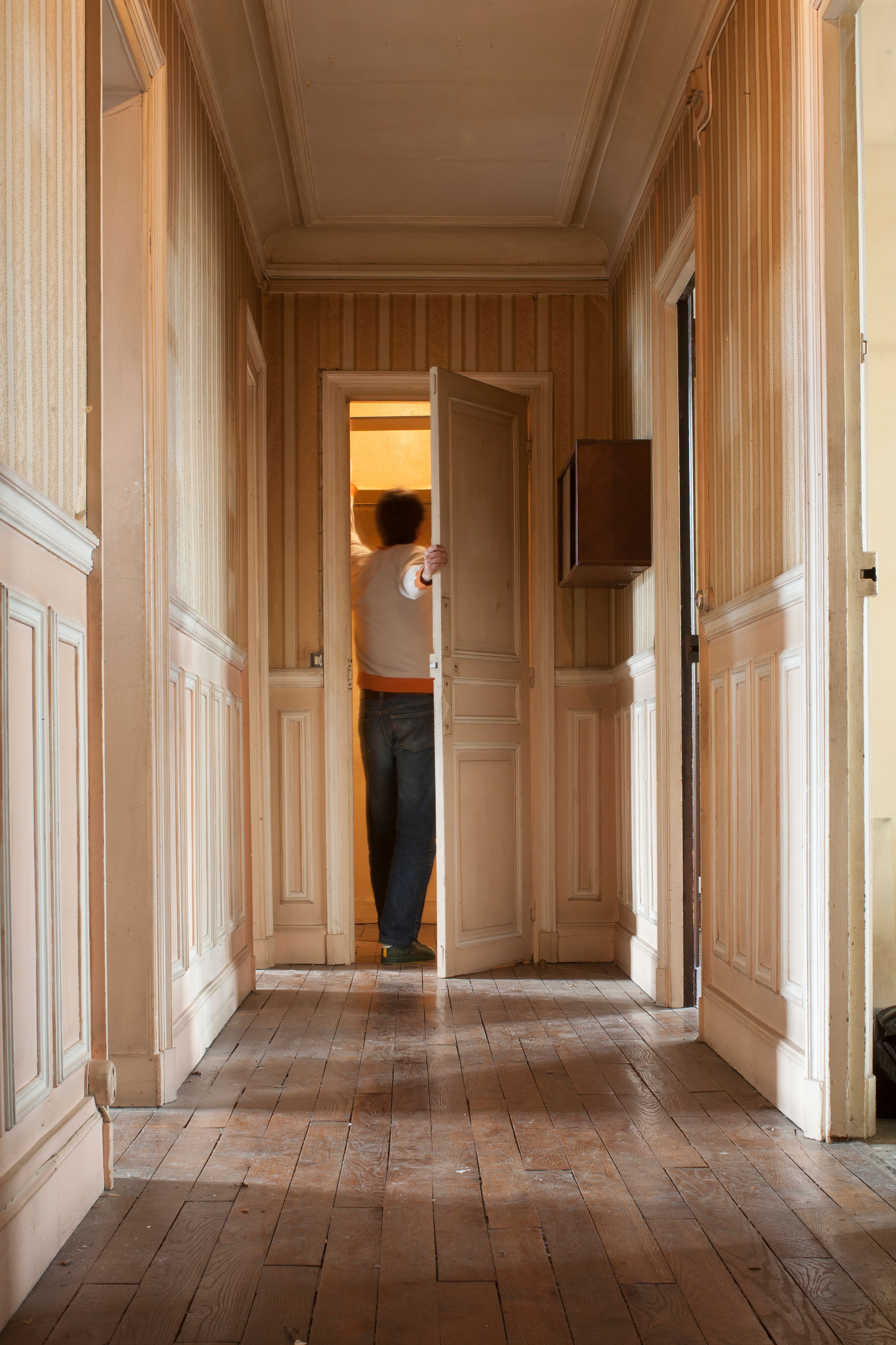 A man opening a door down a hallway. | Source: Getty Images