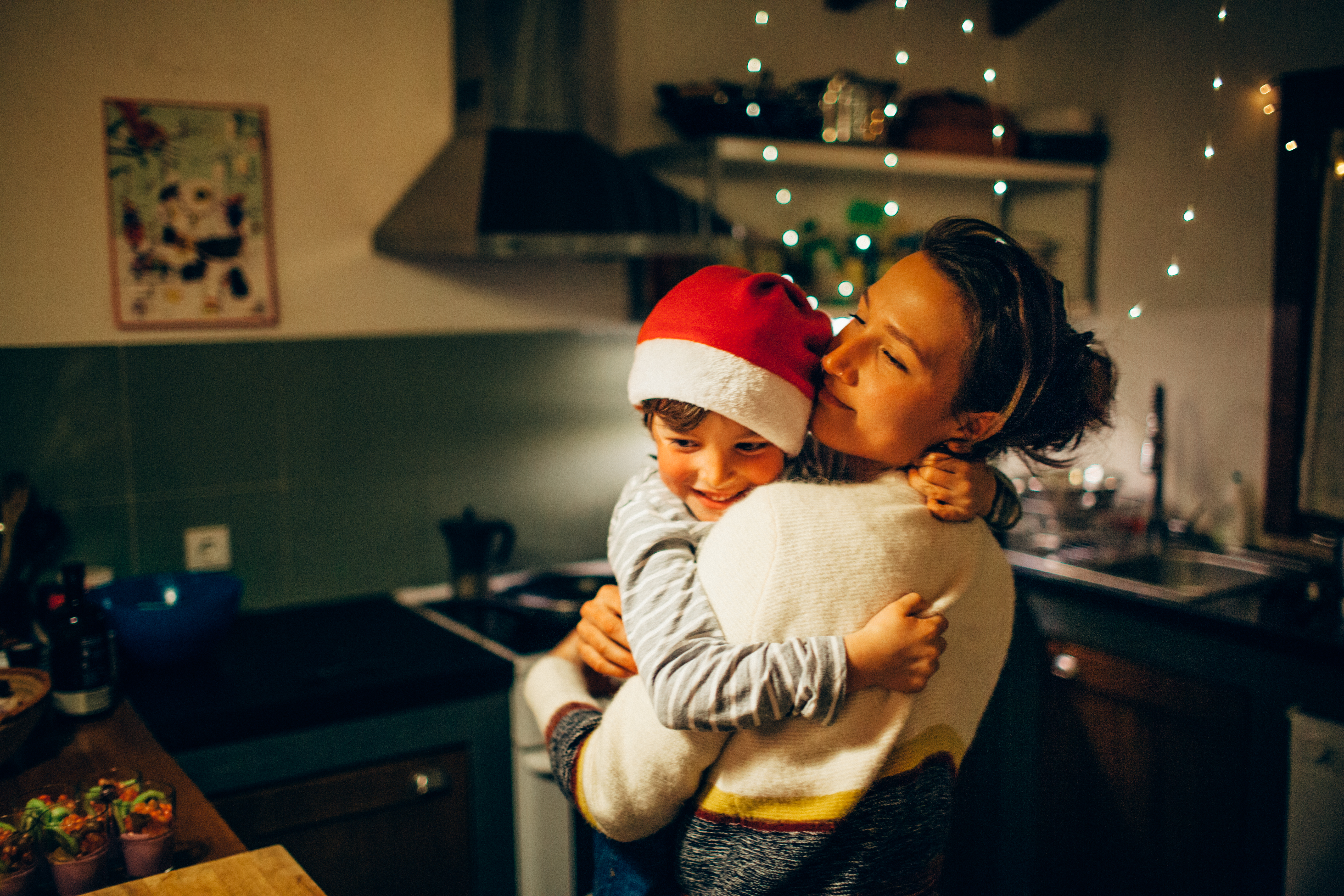 Mother and son hugging in the kitchen at Christmas | Source: Getty Images