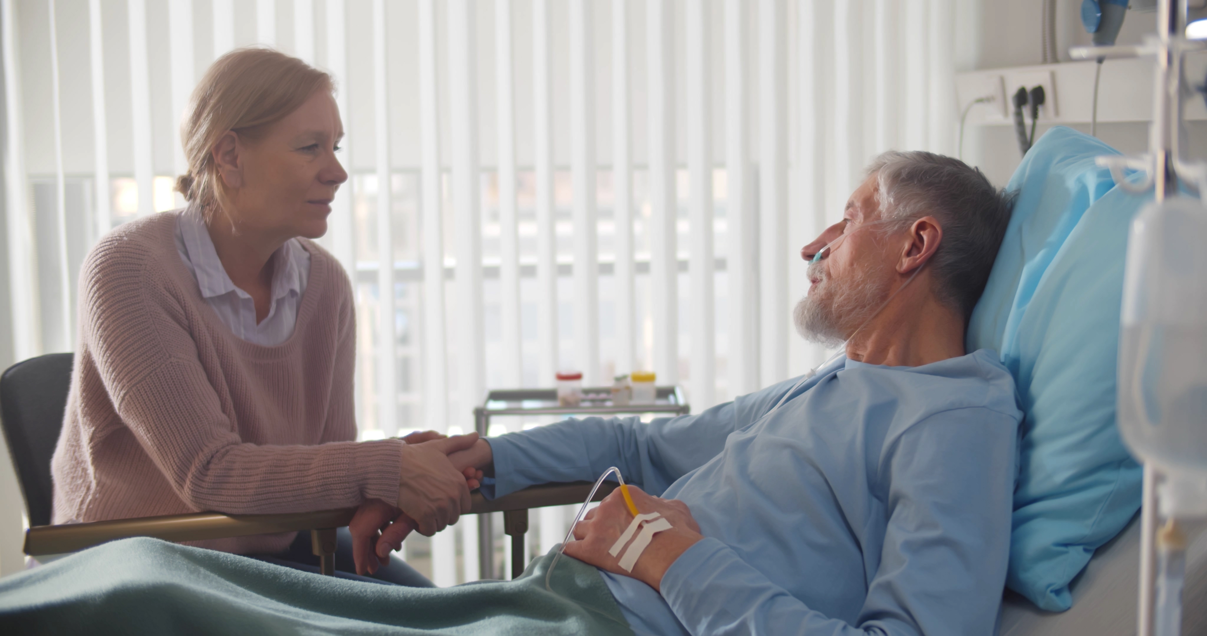 A caring wife holding her ill husband's hand in the hospital | Source: Shutterstock