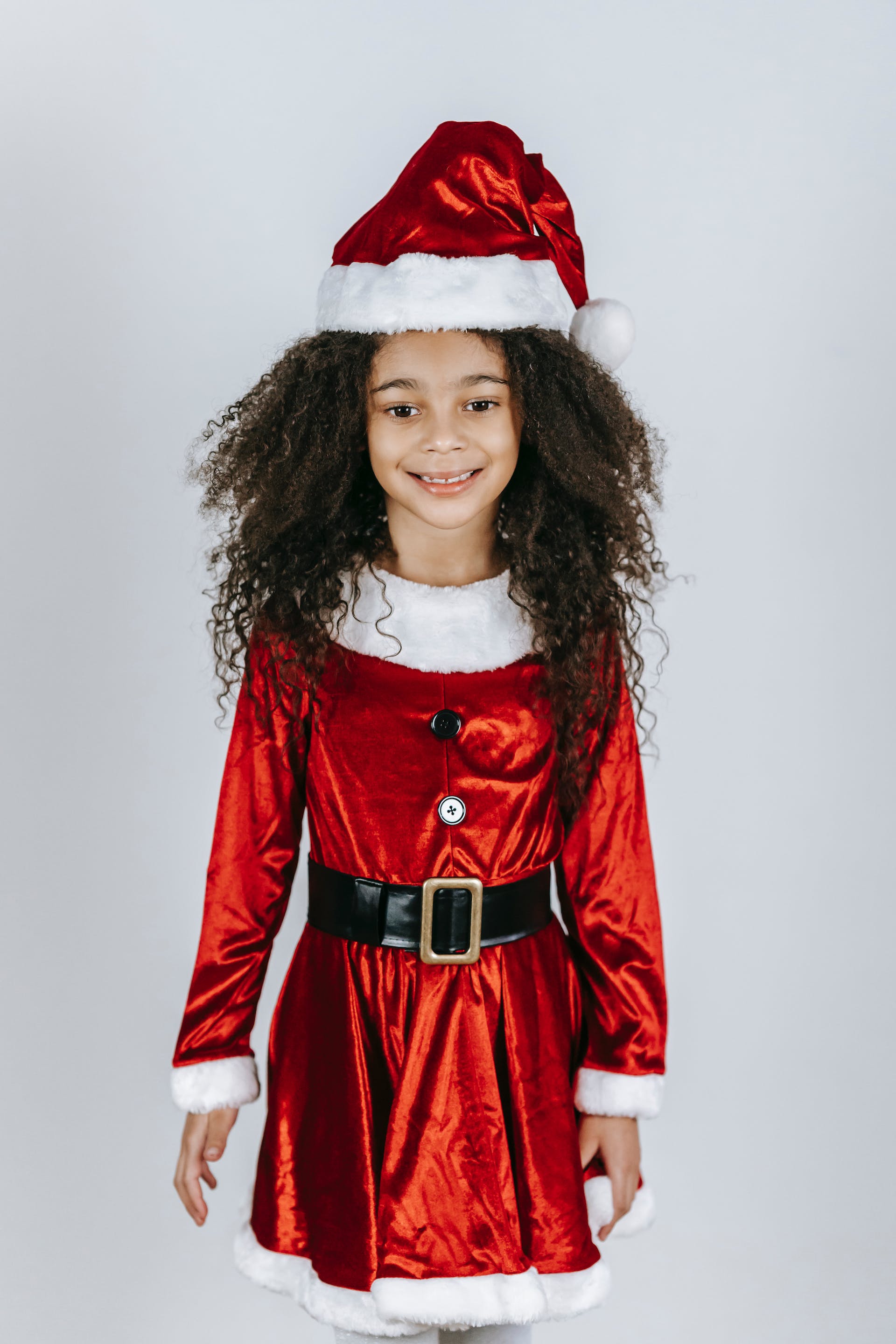 A little girl in Santa Claus outfit | Source: Pexels