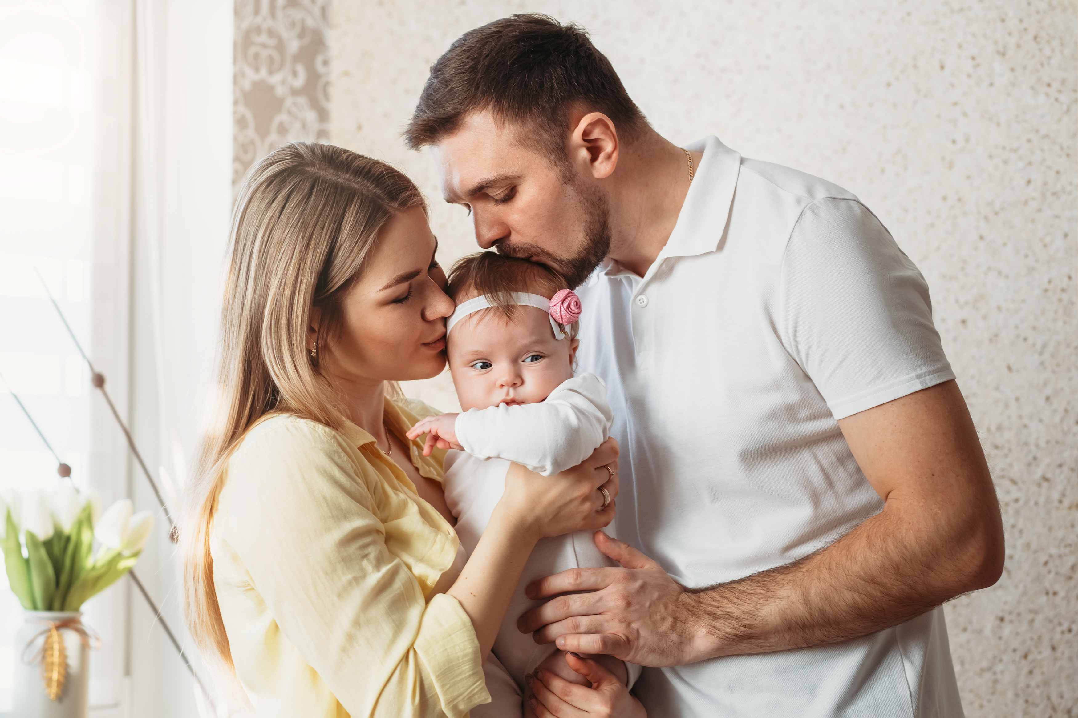 A couple kissing their baby | Source: Shutterstock