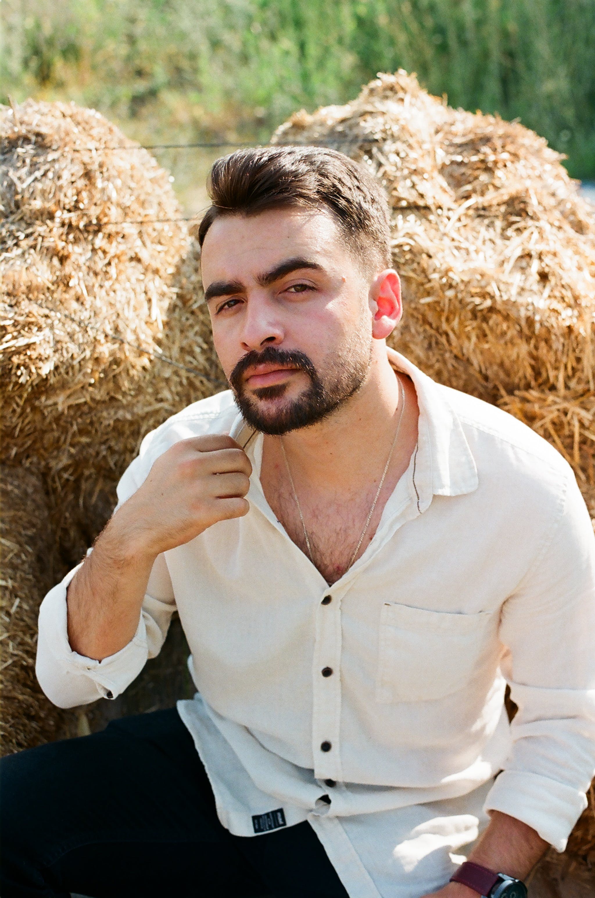 A man sitting by bales of hay | Source: Pexels