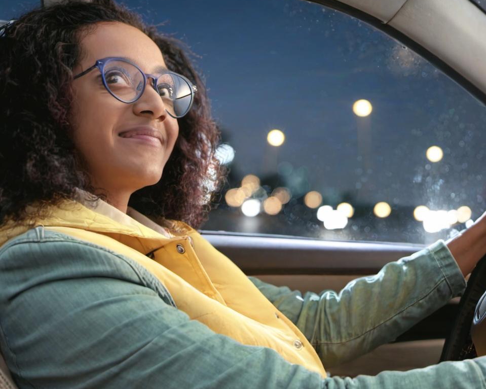 A woman smiling contentedly as she drives | Source: Midjourney