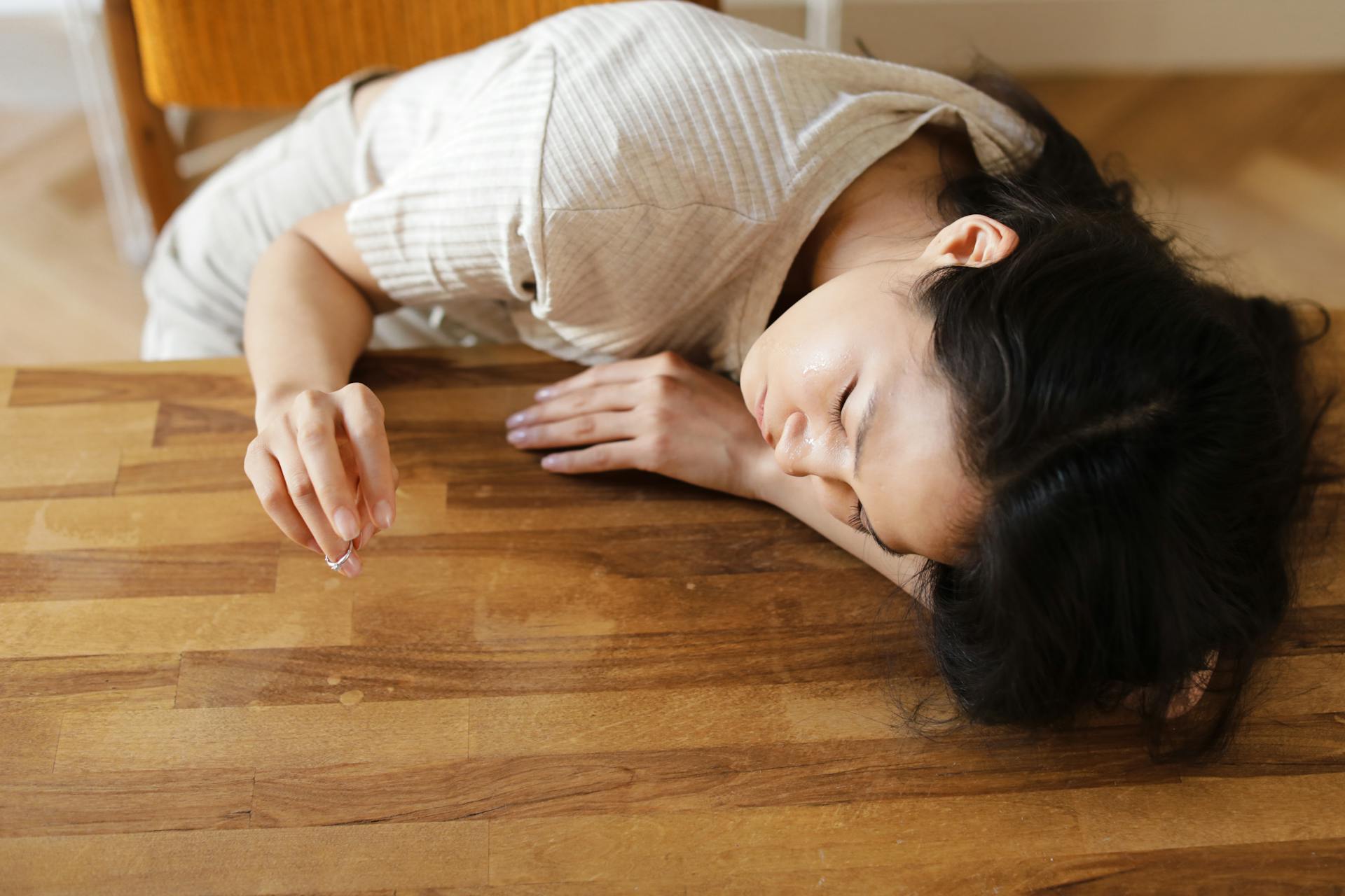 A woman resting her head on a table | Source: Pexels